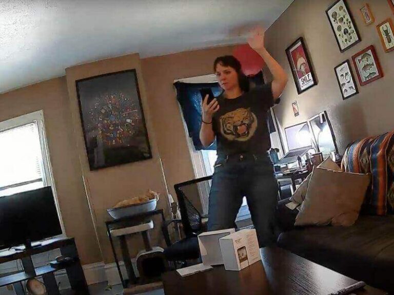 A security camera capturing a woman inside a living room, showing a motion-triggered home security camera recording in action.
