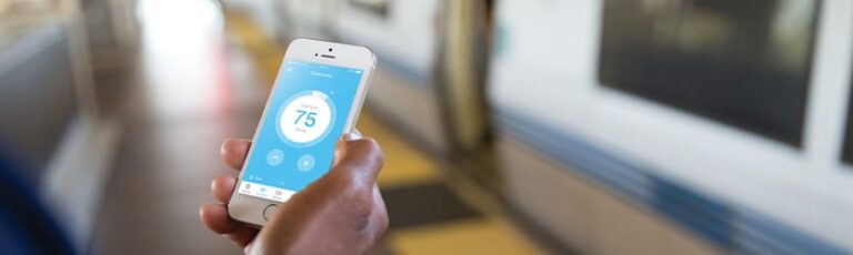 Man holding a white phone with the Vivint App open.