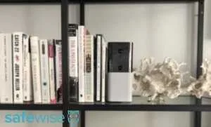 Abode Iota on a bookshelf in an apartment.
