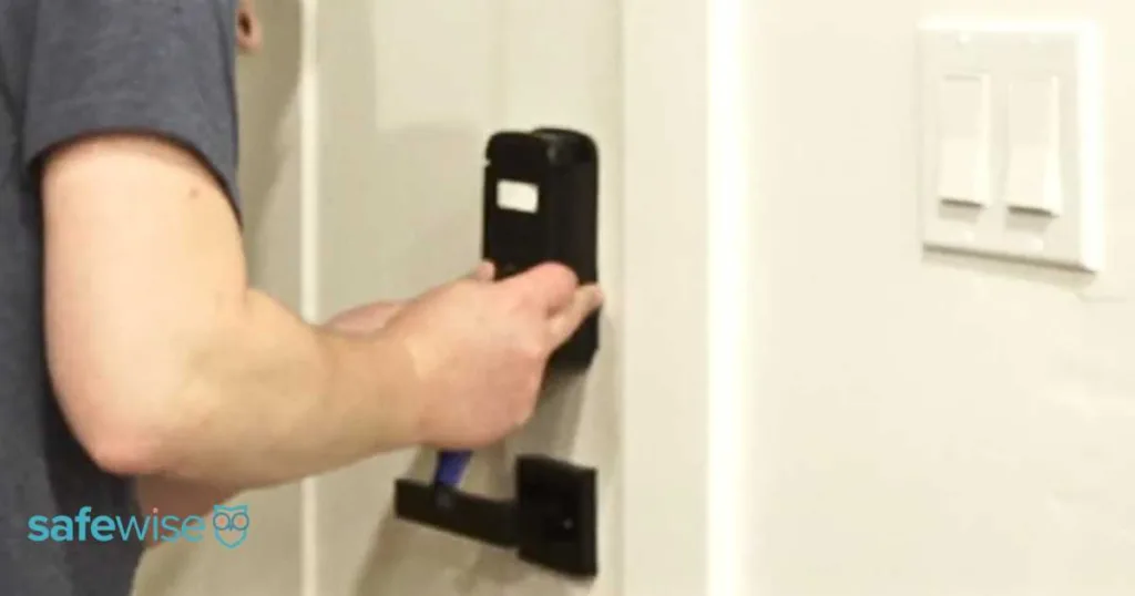 Person installing the Abode smart lock on the inside of a door.