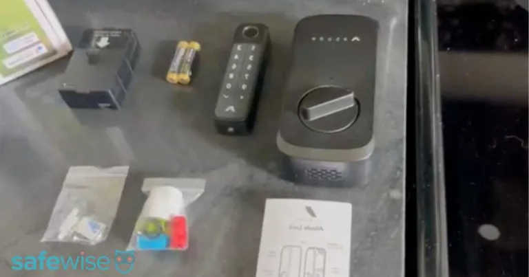 Abode Smart Lock components unboxed and laid out on a table.