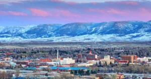 View of Casper, WY with mountains in the background and a pink and purple sky with clouds.