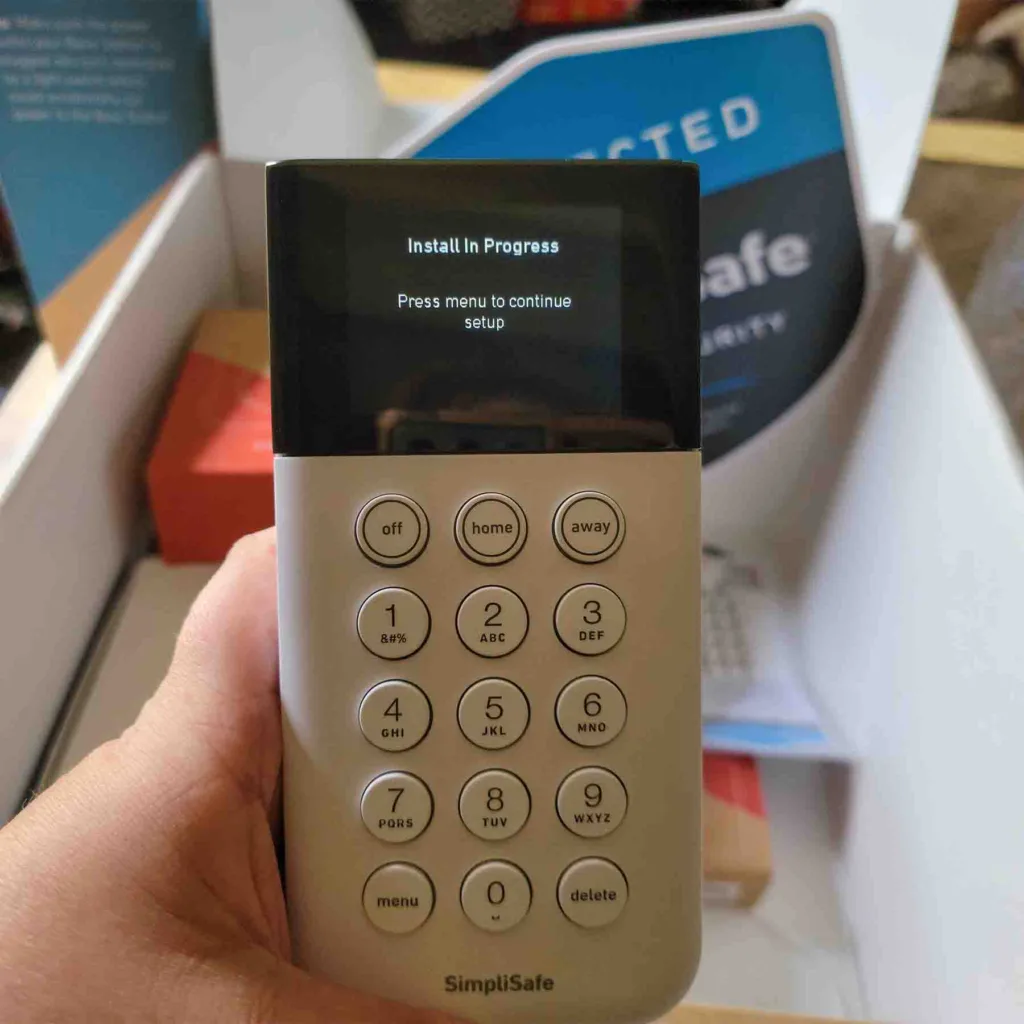 Front view of a SimpliSafe home security system keypad held by a SafeWise tester.