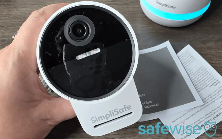 Tester holding the SimpliSafe Outdoor Camera by the base.